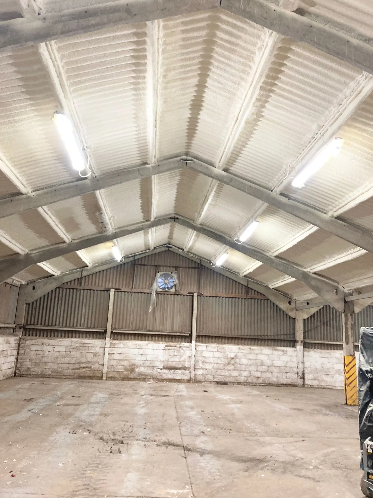Spray foam insulation applied to corrugated roofs — real Duratite Group project