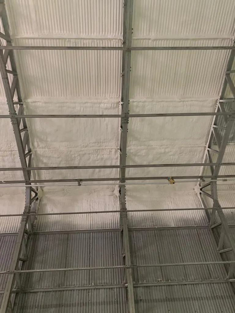 Spray foam following every ridge and trough of a corrugated profile