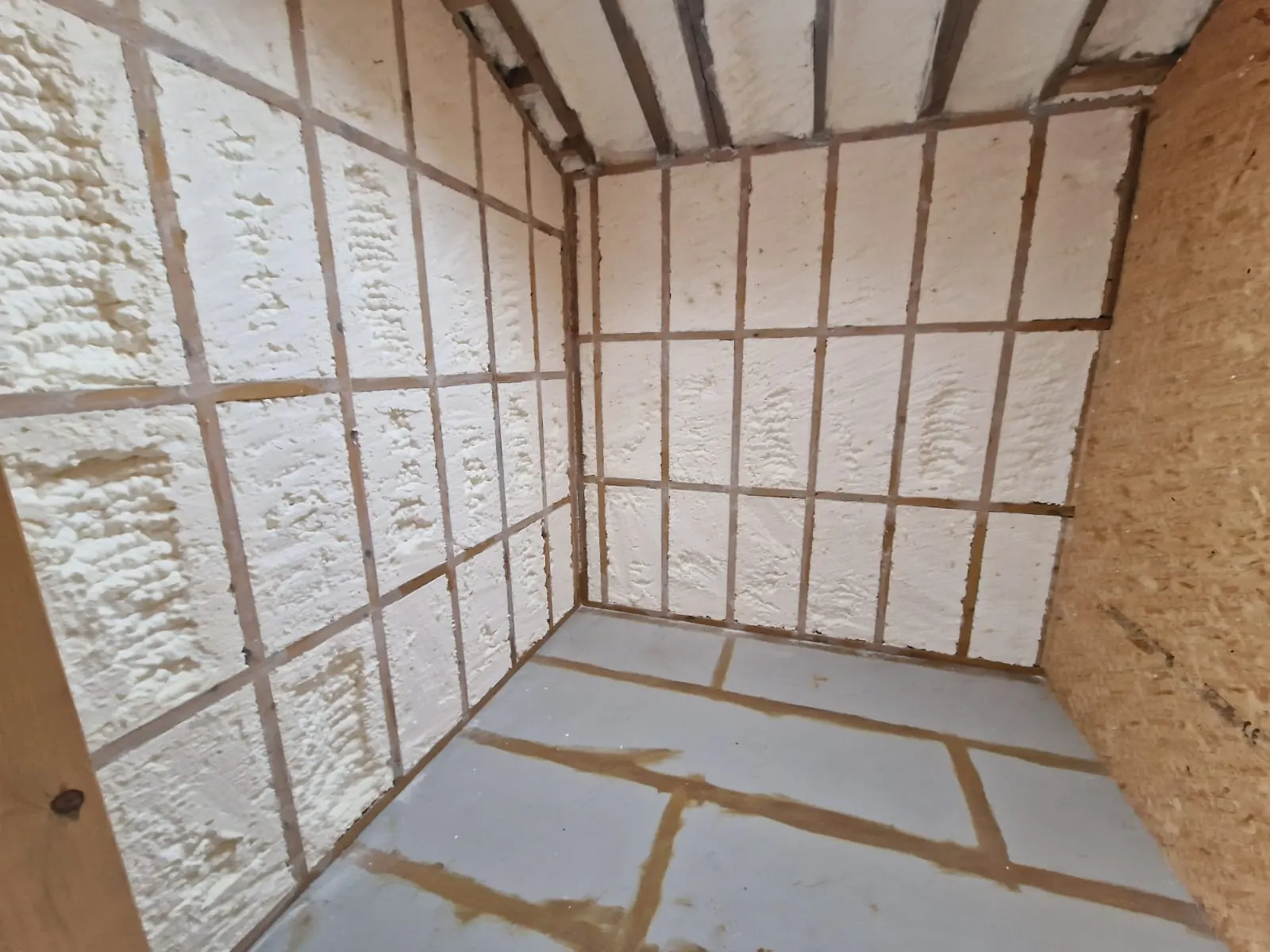 Spray foam insulation applied to stud walls — real Duratite Group project