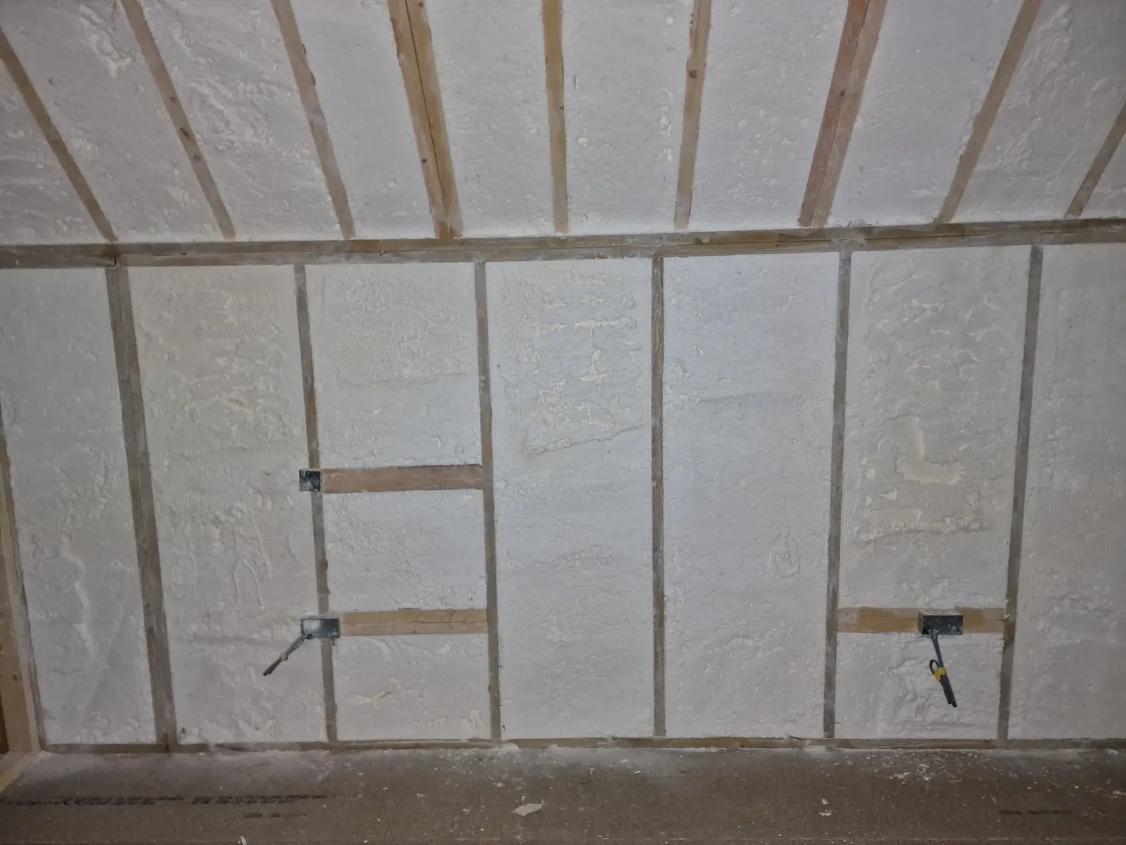 Spray foam insulation applied to stud walls — real Duratite Group project
